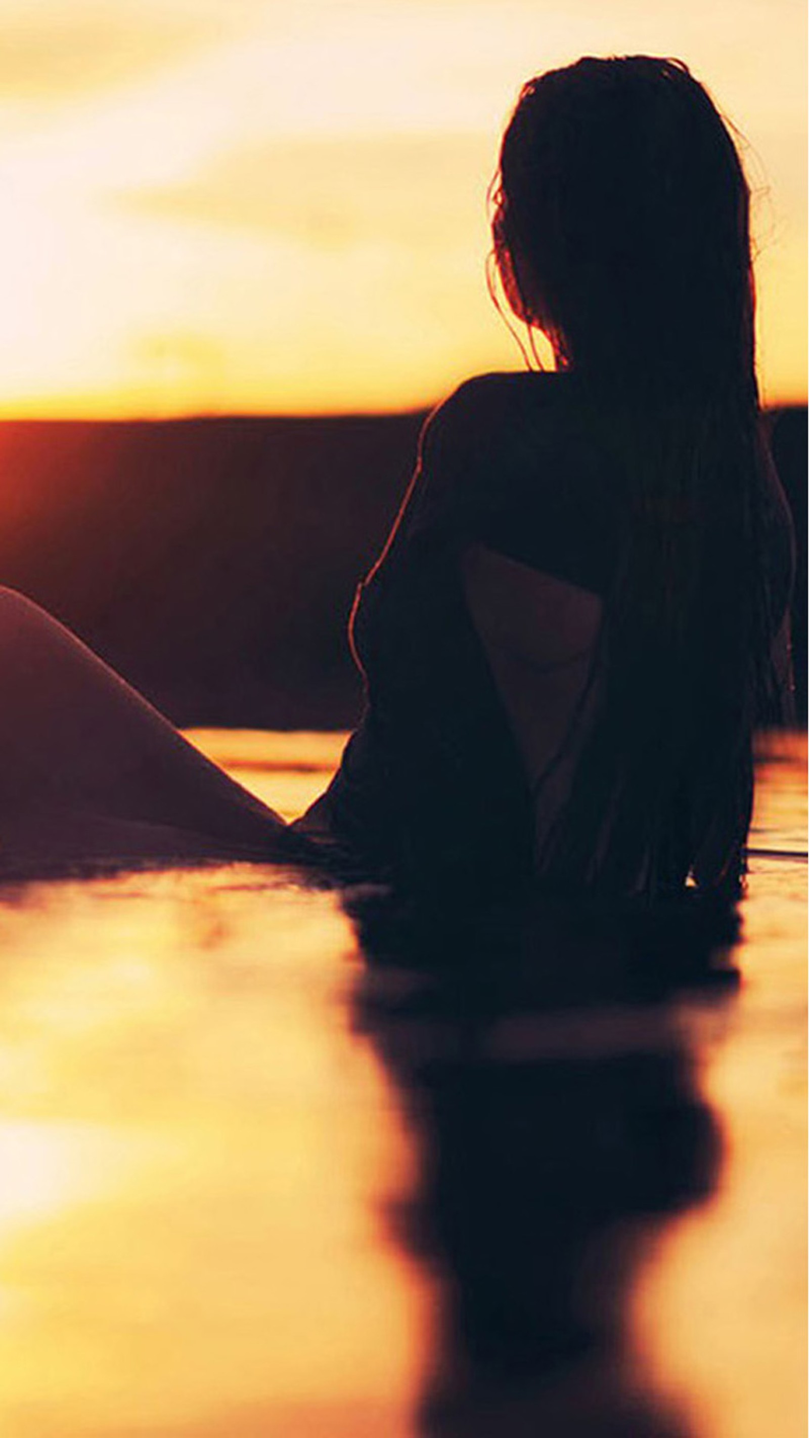 Une image retouchée d'une femme assise dans l'eau au coucher du soleil, les jambes croisées (plage, fille)