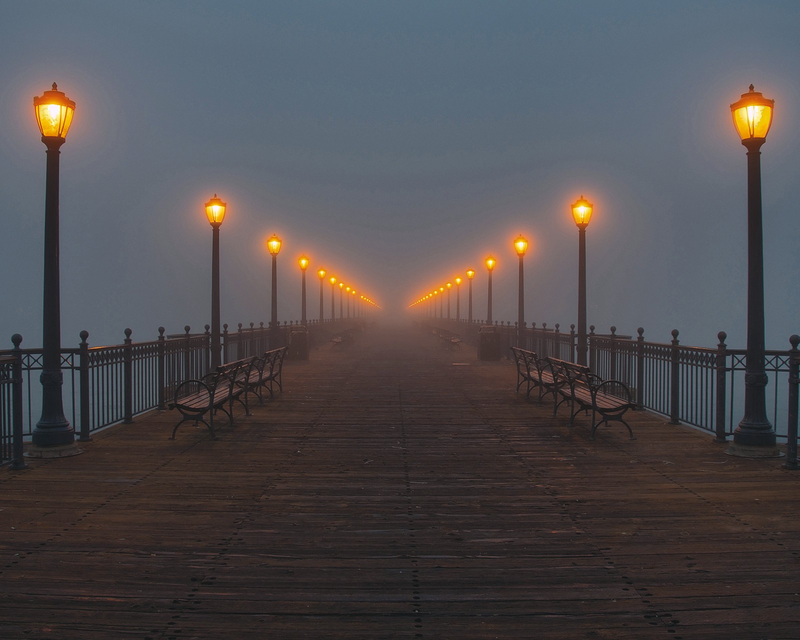 Un muelle con bancos y farolas en una noche neblinosa (puente, oscuro, destino, fin, niebla)