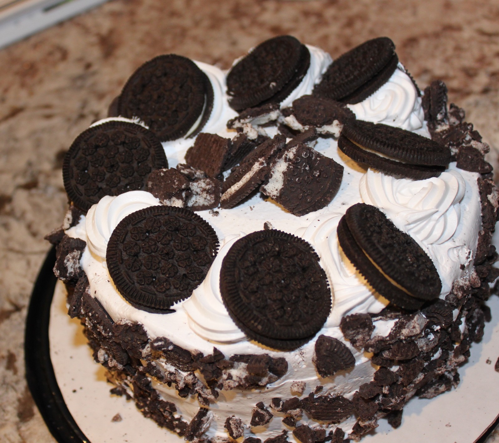 Tarta de galletas oreo y crema en un plato sobre una encimera. (aswome, pastel de oreo)