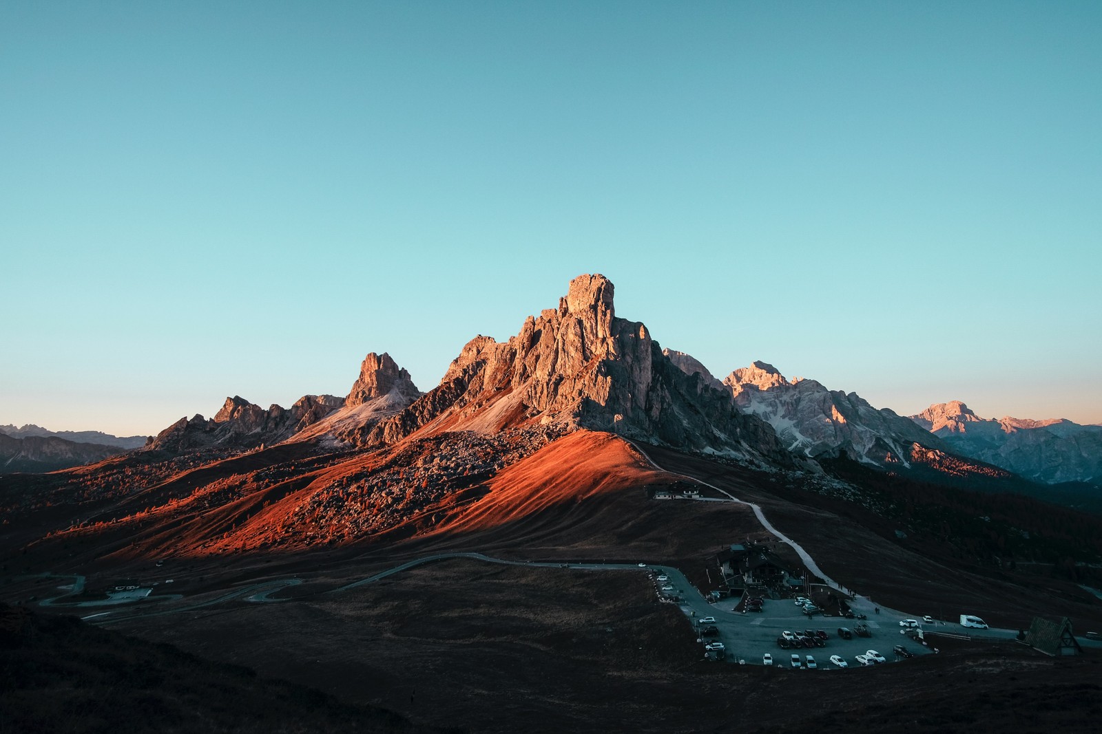 Uma vista de uma cordilheira com uma pequena aldeia em primeiro plano (passo giau, passo de montanha, itália, dolomitas, dolomites)