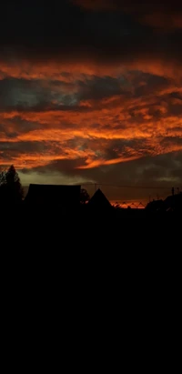 Silhouettes enflammées au coucher du soleil contre un ciel dramatique