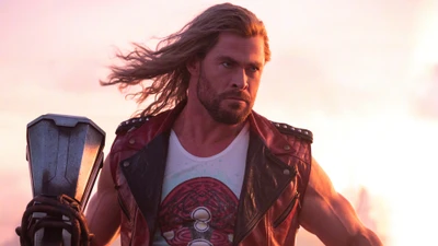 Thor empuñando Stormbreaker en "Thor: Amor y Trueno" contra un dramático fondo de atardecer.