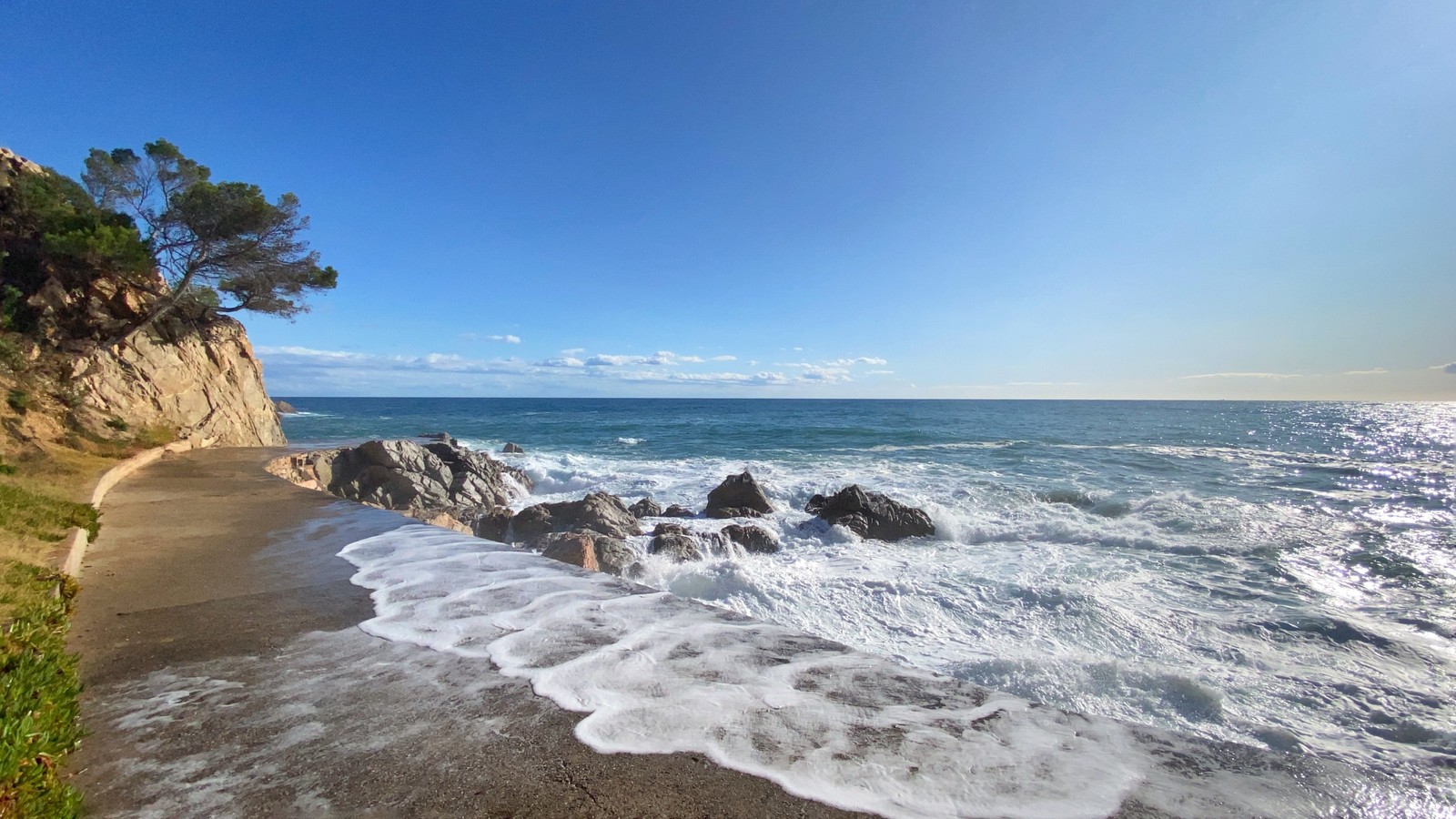 Vue aérienne d'une plage avec une falaise rocheuse et un plan d'eau (la côte, vague de vent, promontoire, physique, science)