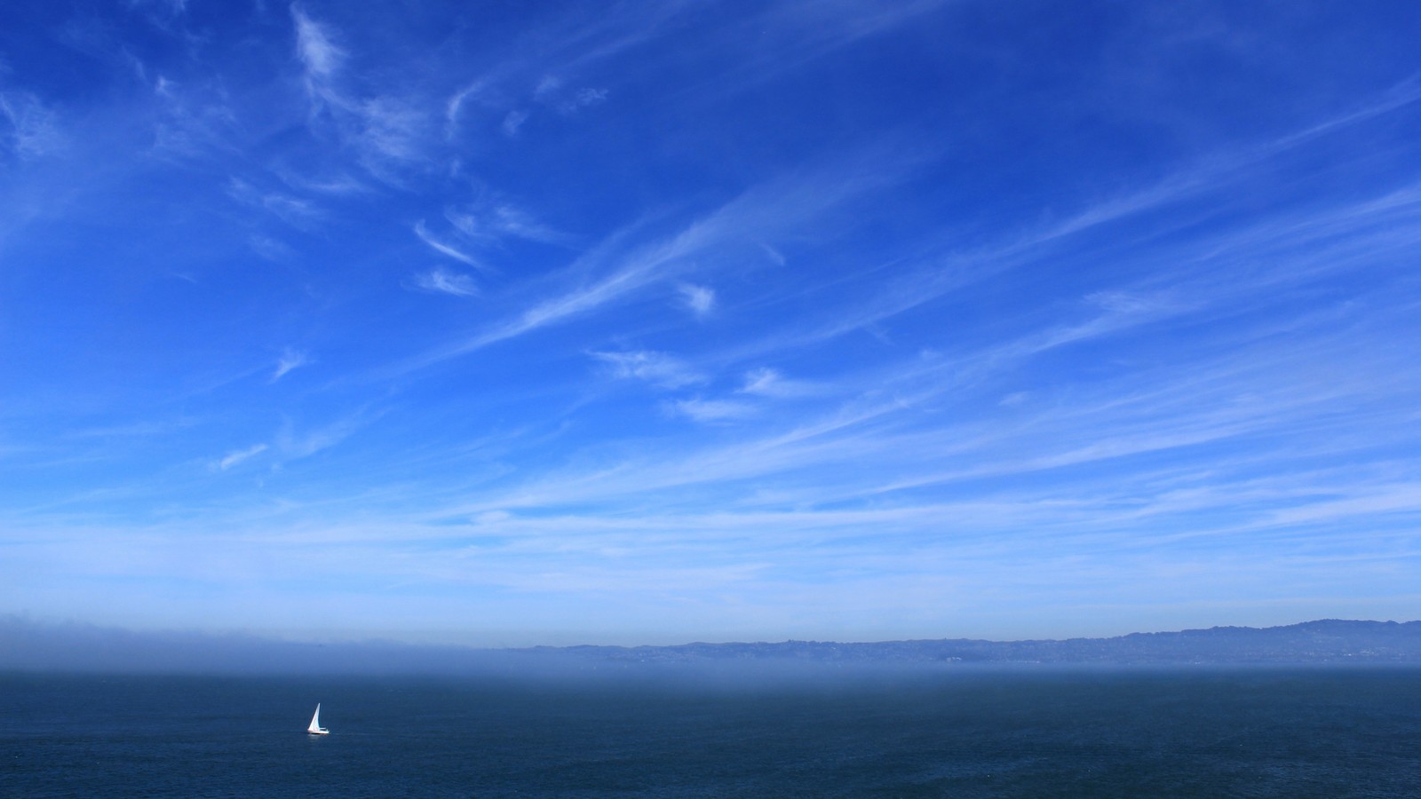 Vista aérea de un velero no oceano com céu azul e nuvens (horizonte, mar, océano, nube, orilla)