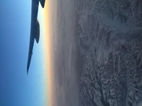 Vuelo nocturno sobre montañas cubiertas de nieve bajo una vasta atmósfera