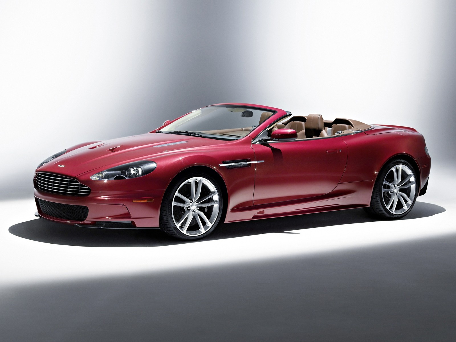 Um carro esportivo vermelho está estacionado em uma sala branca (aston martin dbs v12, aston martin db9, salão internacional do automóvel de genebra, aston martin vantage, motor v12)