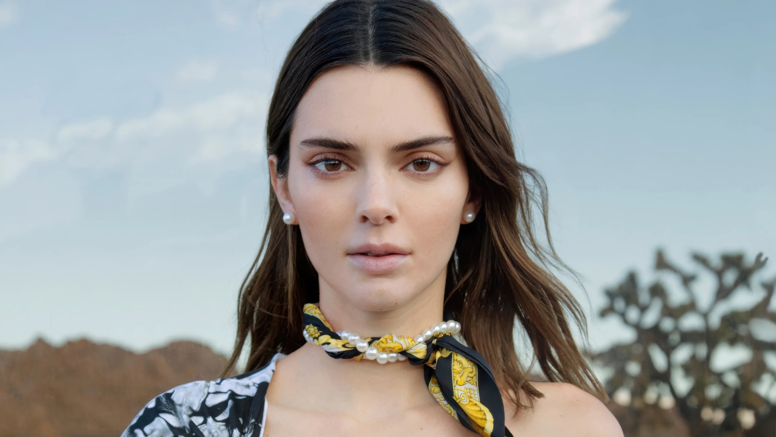 Une femme avec un haut floral jaune et noir et un nœud papillon jaune et noir (kendall jenner, modèle, américain, célébrité, filles)