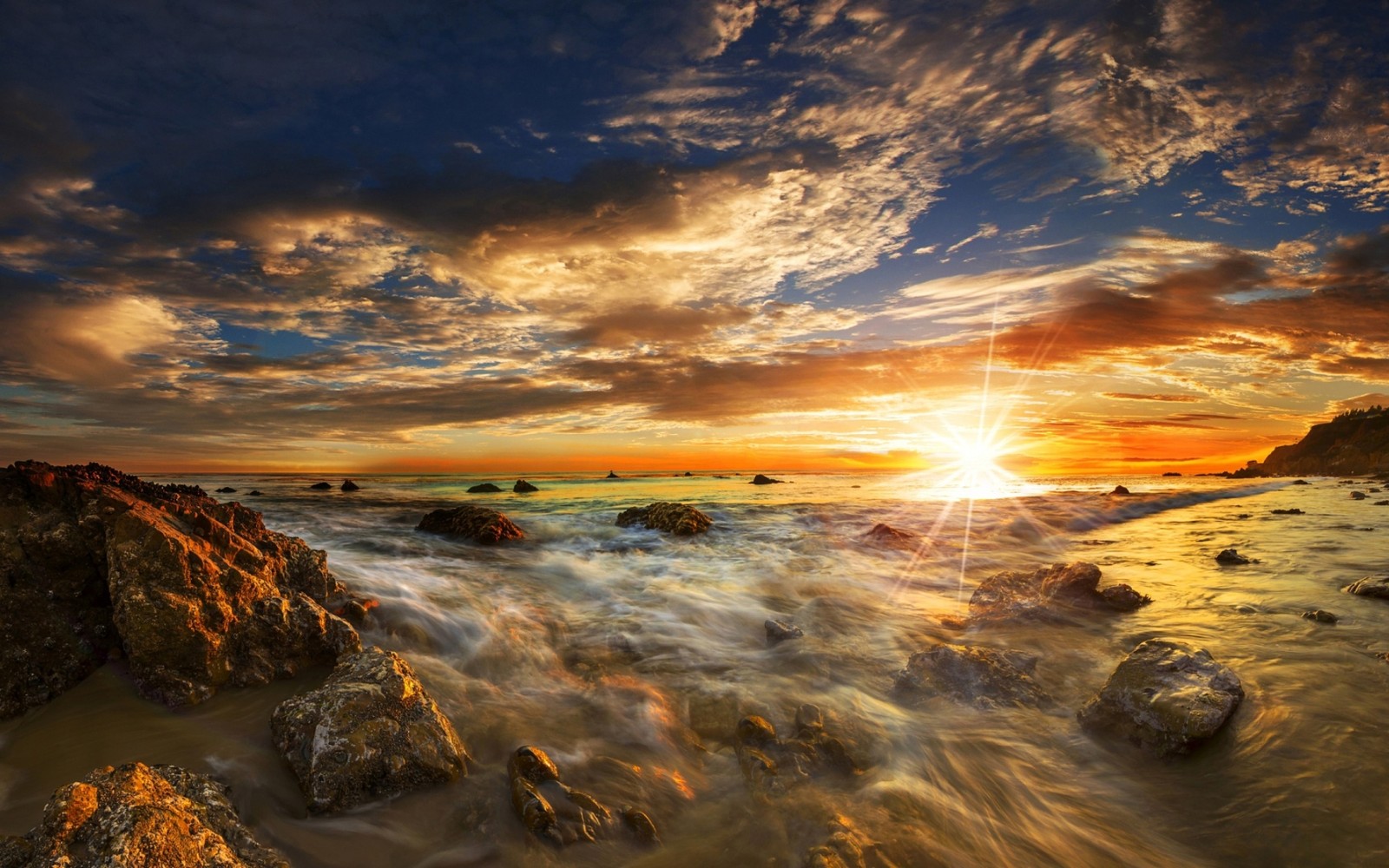 Ein sonnenuntergang über dem ozean mit felsen und wasser (sonnenuntergang, sonnenaufgang, bernstein, horizont, sonnenlicht)