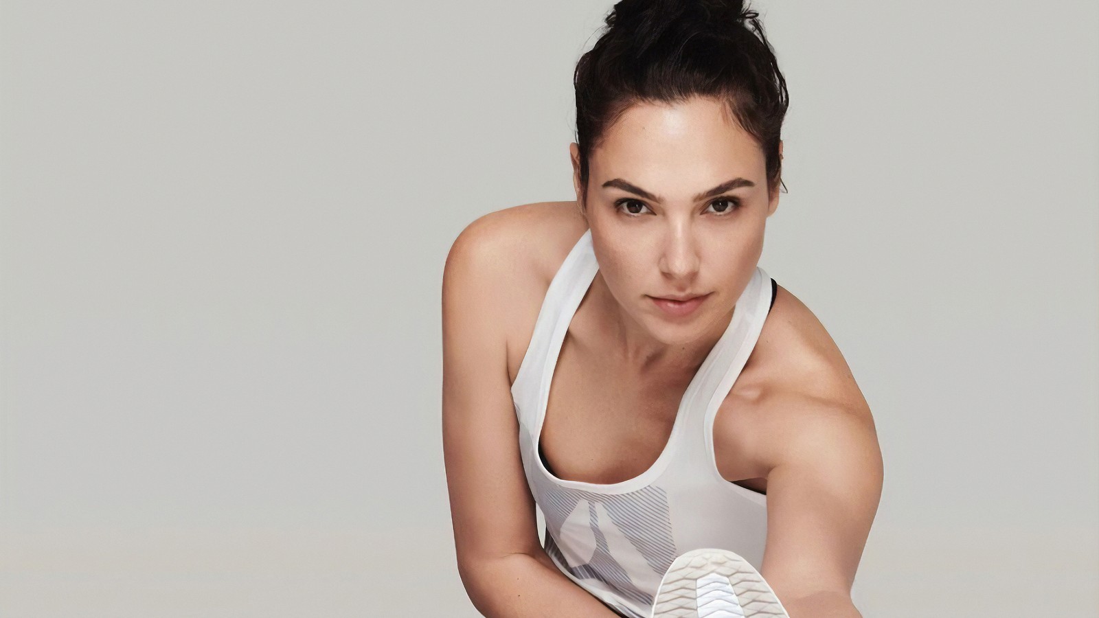 Femme arabe en débardeur blanc et baskets blanches posant pour une photo (gal gadot, reebok, actrice, célébrité, femmes)