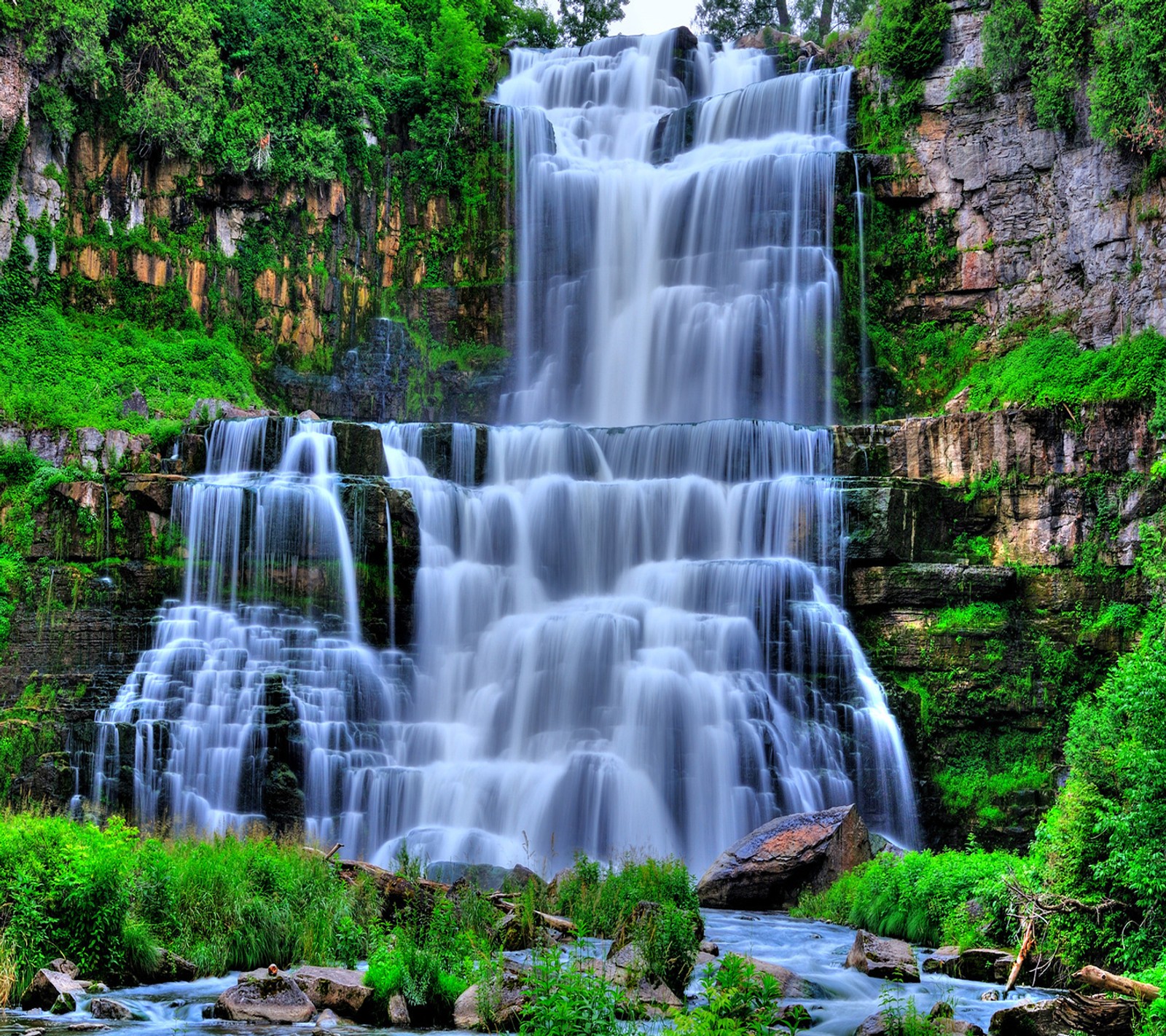 A close up of a waterfall with a forest in the background (good, look)