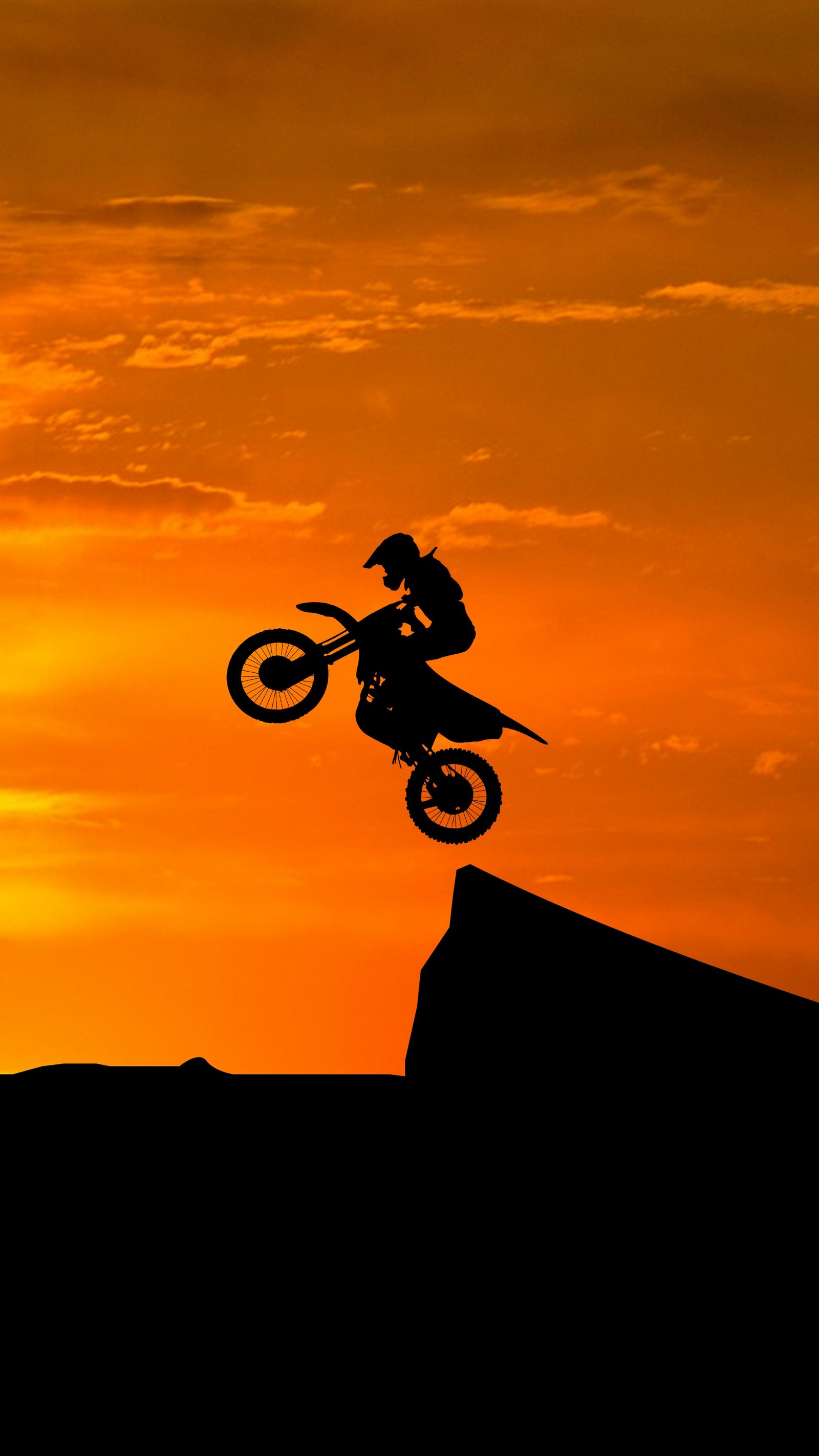 Un motociclista haciendo un truco en una moto de cross al atardecer (moto, cruz, motocross)