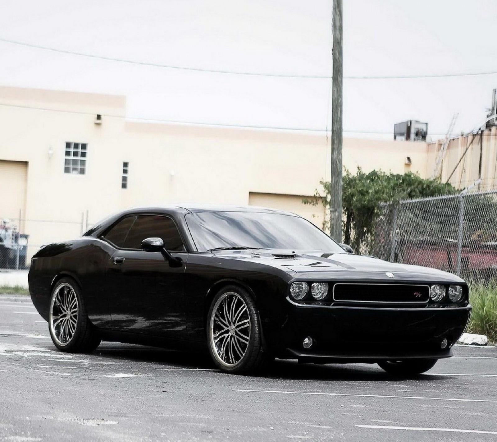 Image aérienne d'une voiture musclée noire garée dans un parking (challenger, dodge)