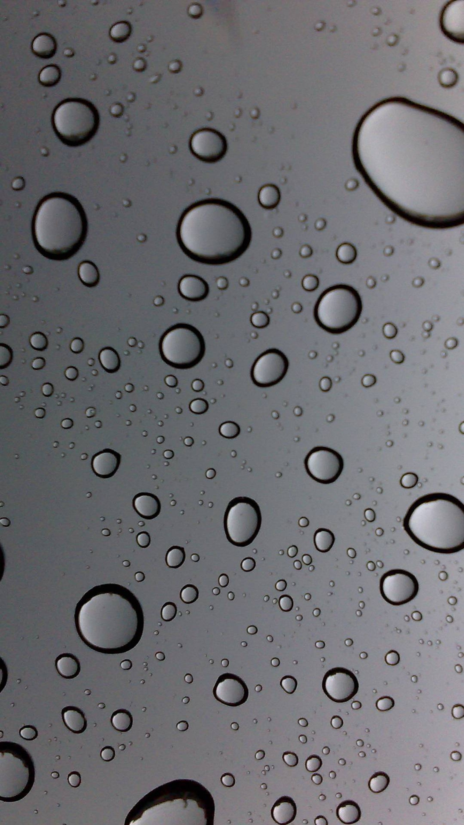 Gros plan d'un tas de gouttes d'eau sur une surface (gouttes, pluie)