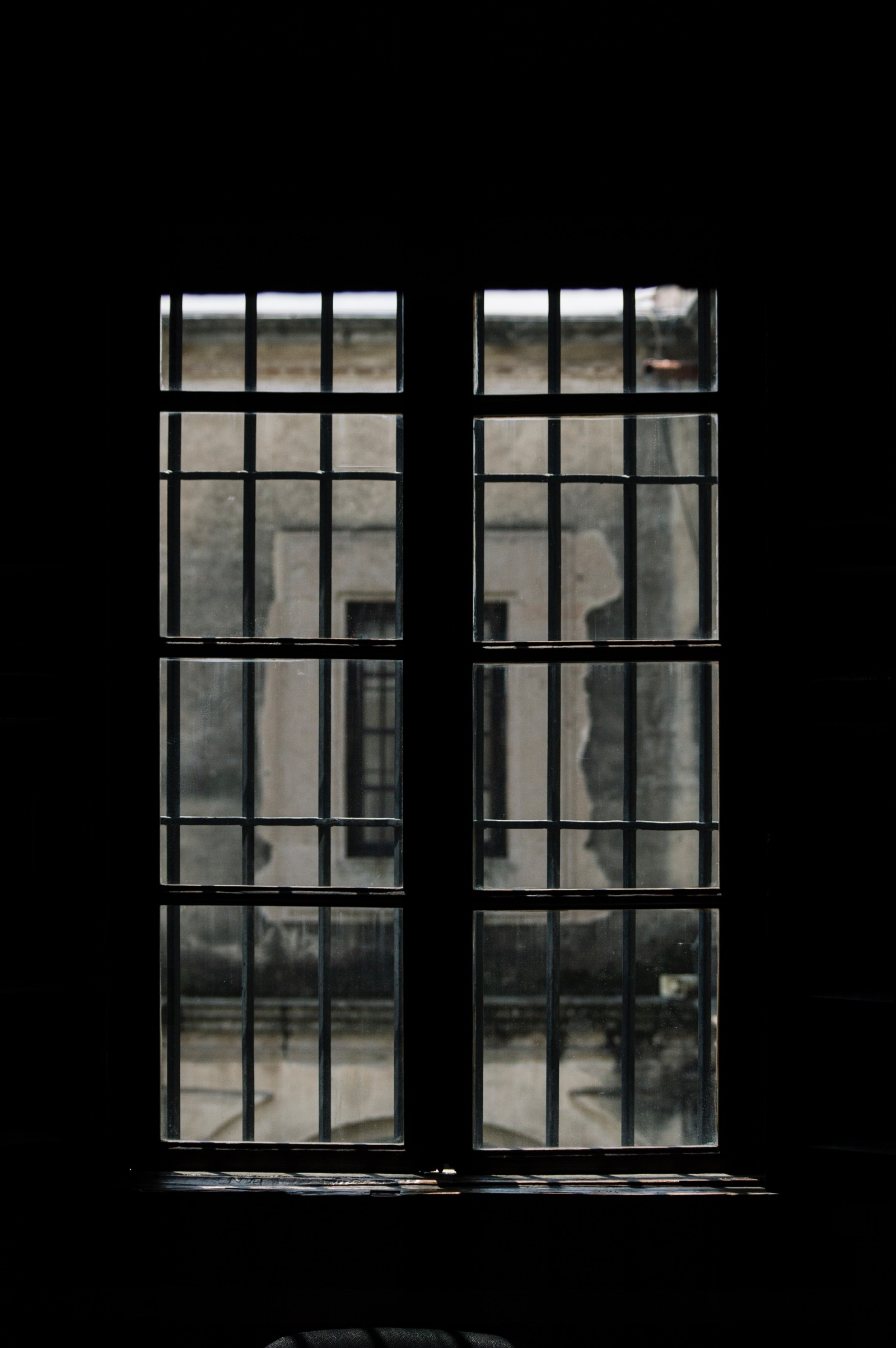 There is a window with a view of a building through it (window, architecture, glass, daylighting, door)