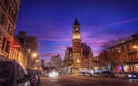 Plaza de la ciudad encantadora con torre del reloj histórica al anochecer