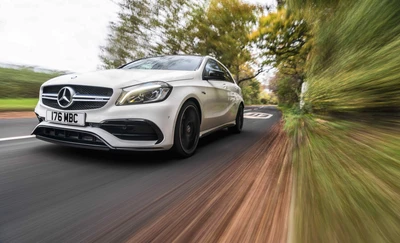 Tomada dinâmica de um Mercedes-Benz AMG hatchback em uma estrada cênica