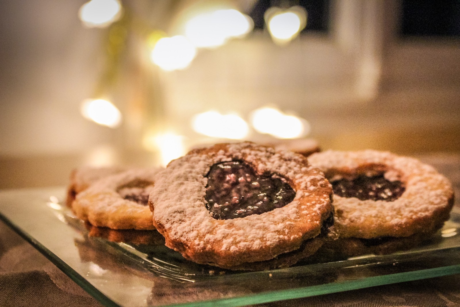 Hay algunas galletas en un plato de vidrio sobre la mesa (postre, pastelería, macarón, horneado, pastel)