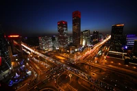 Vibrant night skyline of a bustling metropolis with illuminated skyscrapers and busy streets.