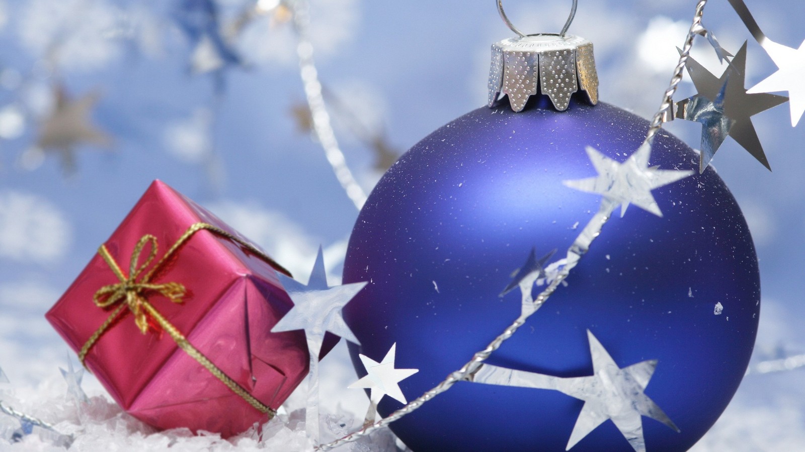 Um close-up de um enfeite de natal azul com um presente na neve (ano novo, dia de natal, feriado, ornamento de natal, enfeite de natal)