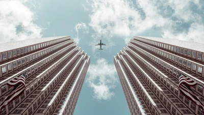 Vista aérea de arranha-céus com avião no céu diurno