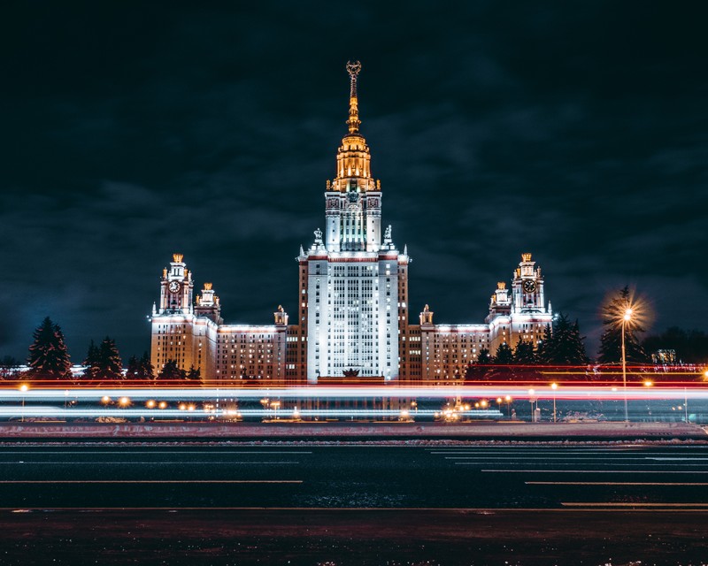 Ночной вид на большое здание с часовой башней и уличным фонарем (московский государственный университет, достопримечательность, ночь, город, городская территория)