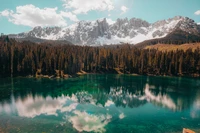 Reflexão serena da montanha em um lago claro cercado por árvores de lariço