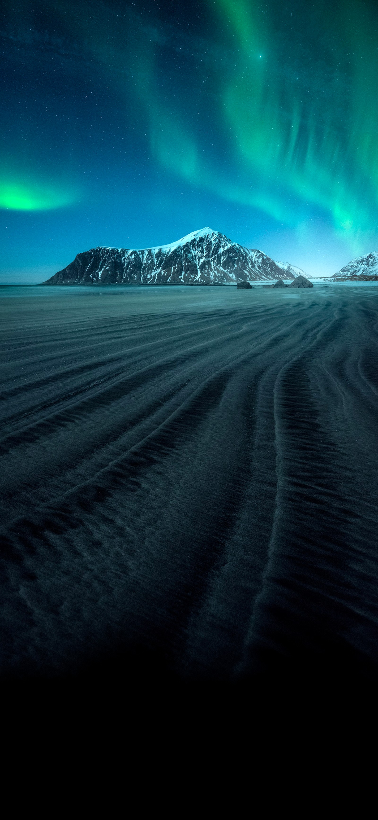 Une vue aérienne d'une montagne avec une lumière aurorale verte dans le ciel (atmosphère, nuage, montagne, lumière, nature)