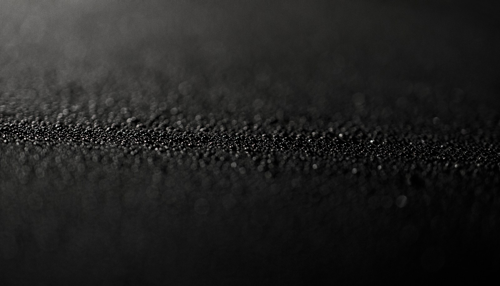 A close up of a black and white photo of a tennis ball (black, water, darkness, black and white, monochrome)