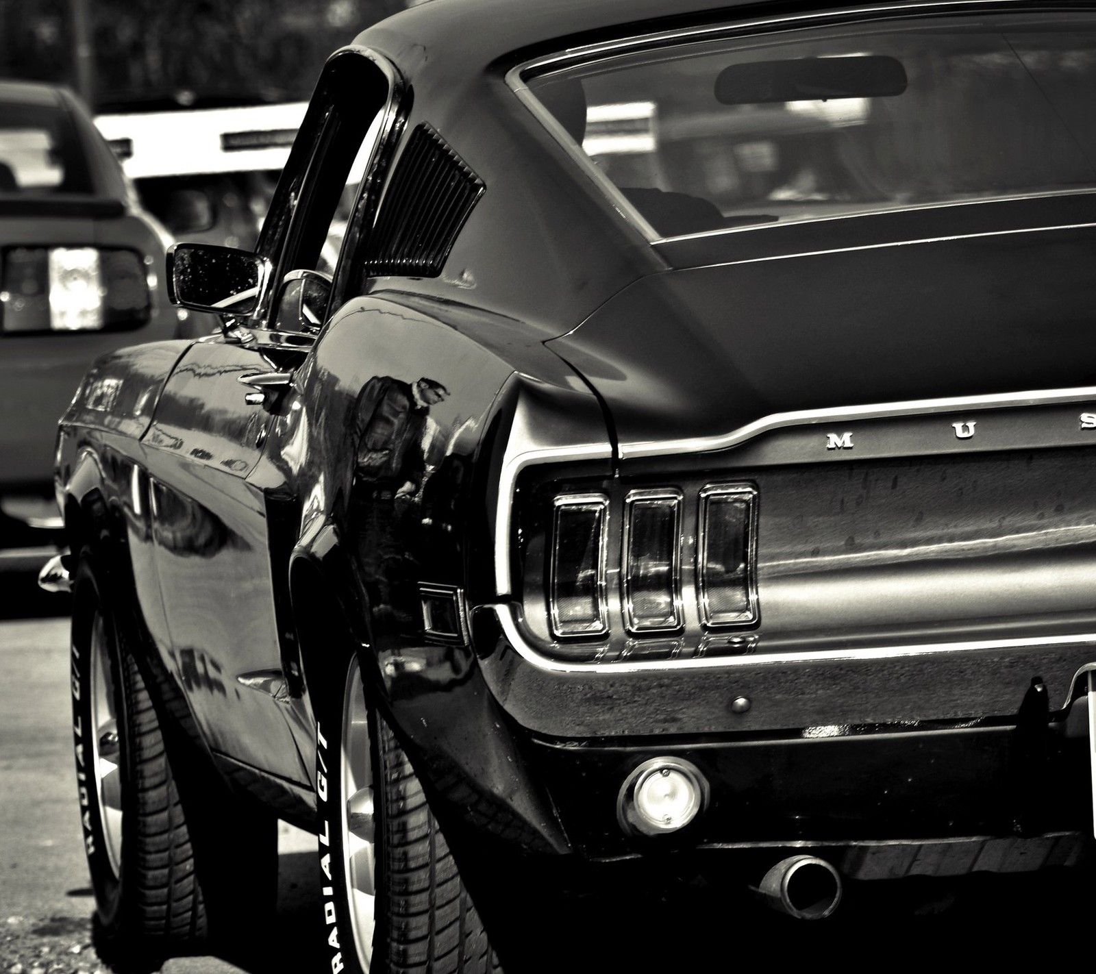 Una imagen borrosa en blanco y negro de un automóvil clásico (negro, coche, músculo, camino)