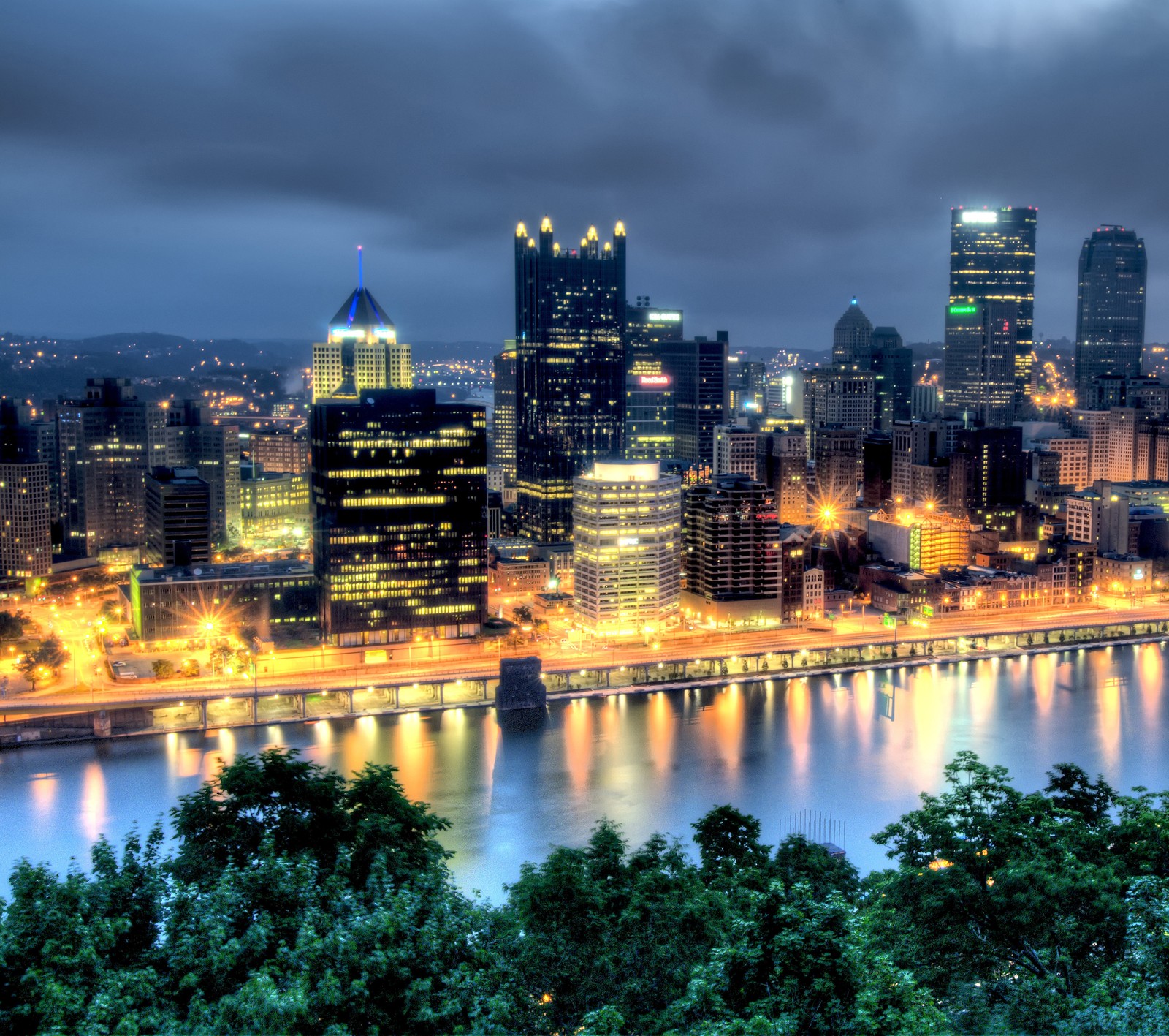 Vista aérea de una ciudad de noche con un río que la atraviesa (pingüinos, pensilvania, piratas, pitt, pittsburgh)