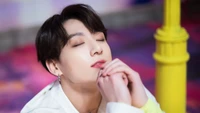 Jungkook em uma pose contemplativa, exalando carisma e emoção.