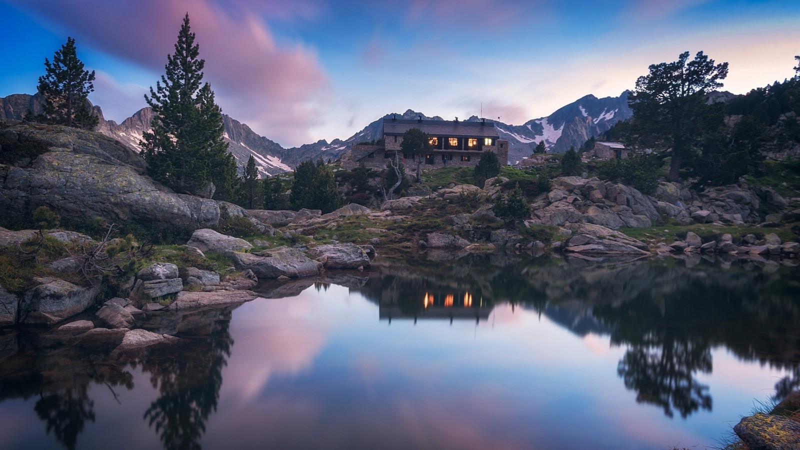 Haus auf einem felsigen hügel mit einem see davor (reflexion, gebirgskette, berg, wasser, wolke)