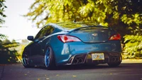 Sleek Blue Hyundai Genesis Coupe with Sporty Rims in a Scenic Outdoor Setting