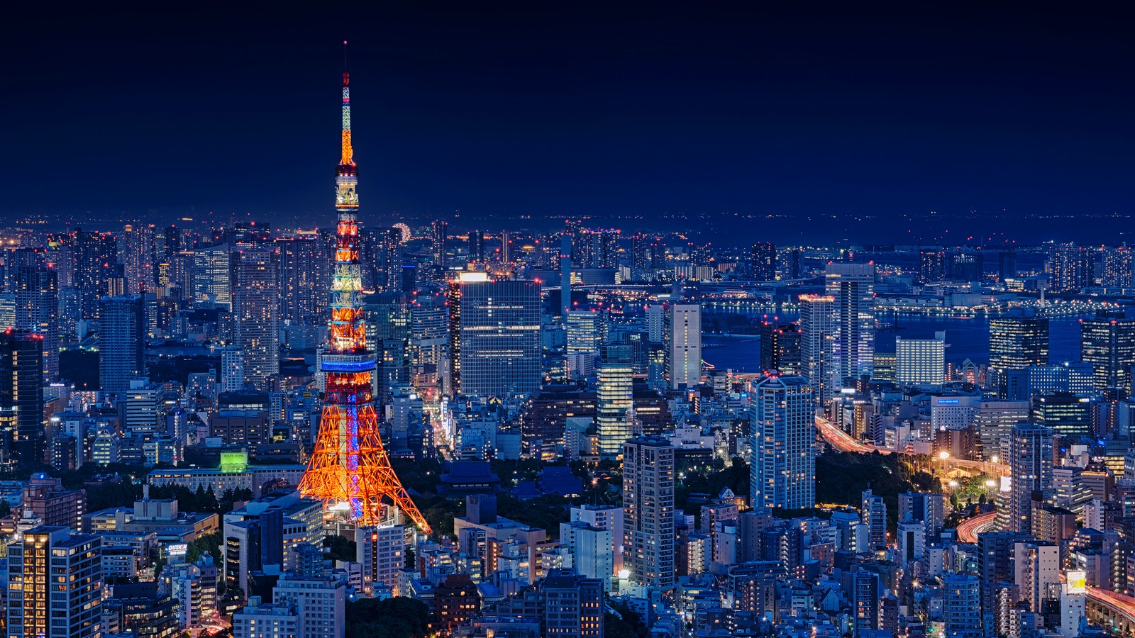 Uma vista aérea de uma cidade à noite com uma grande torre (torre de tóquio, tokyo tower, roppongi hills, cidade, paisagem urbana)