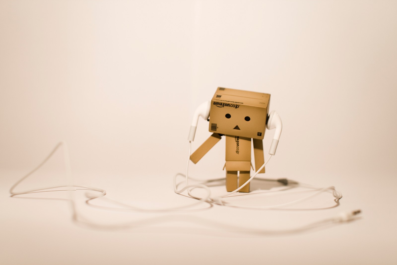 Ein papproboter mit kopfhörern auf einer weißen oberfläche (danbo, papier, animation, karton, illustration)