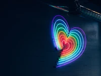 Signo de corazón neón vibrante en colores arcoíris