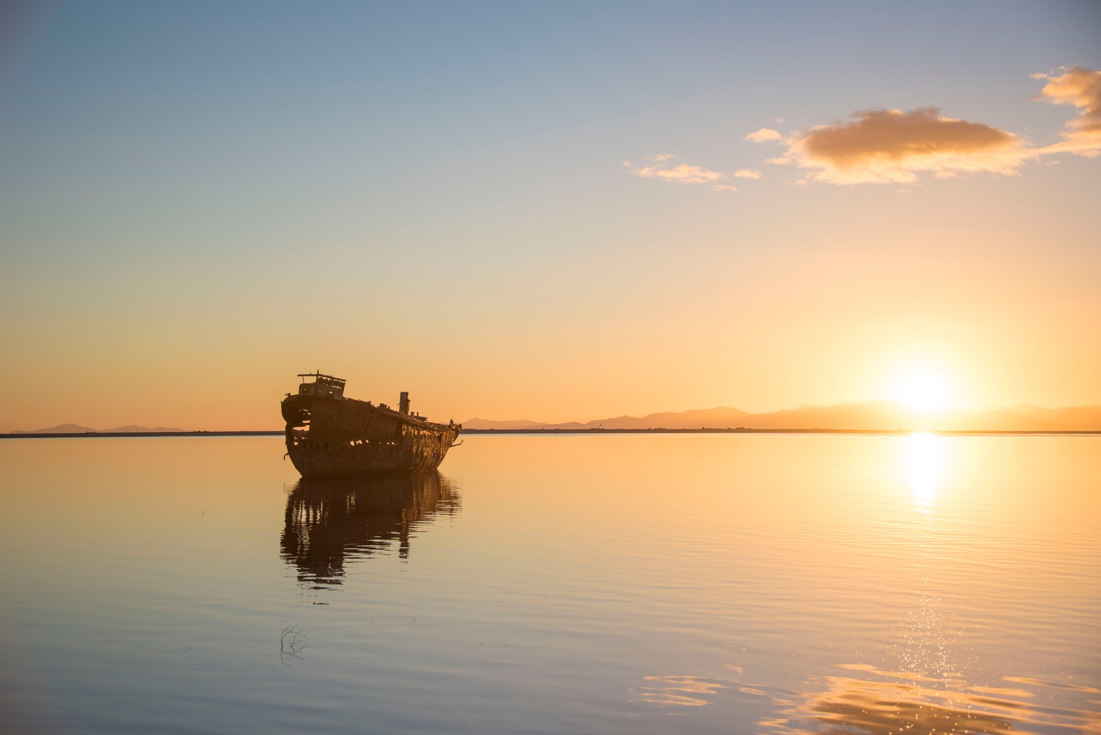 Ein boot, das bei sonnenuntergang im wasser schwimmt (horizont, sonnenuntergang, reflexion, morgen, ruhig)