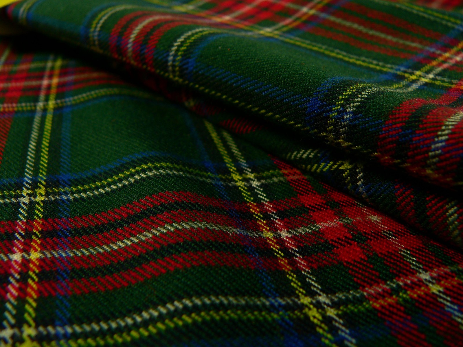 A close up of a plaid fabric with a red and green design (tartan, woven fabric, textile, green, trousers)