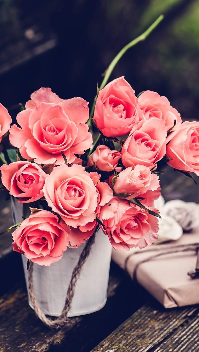 Il y a un vase de roses roses assis sur un banc (fleurs, vintage)