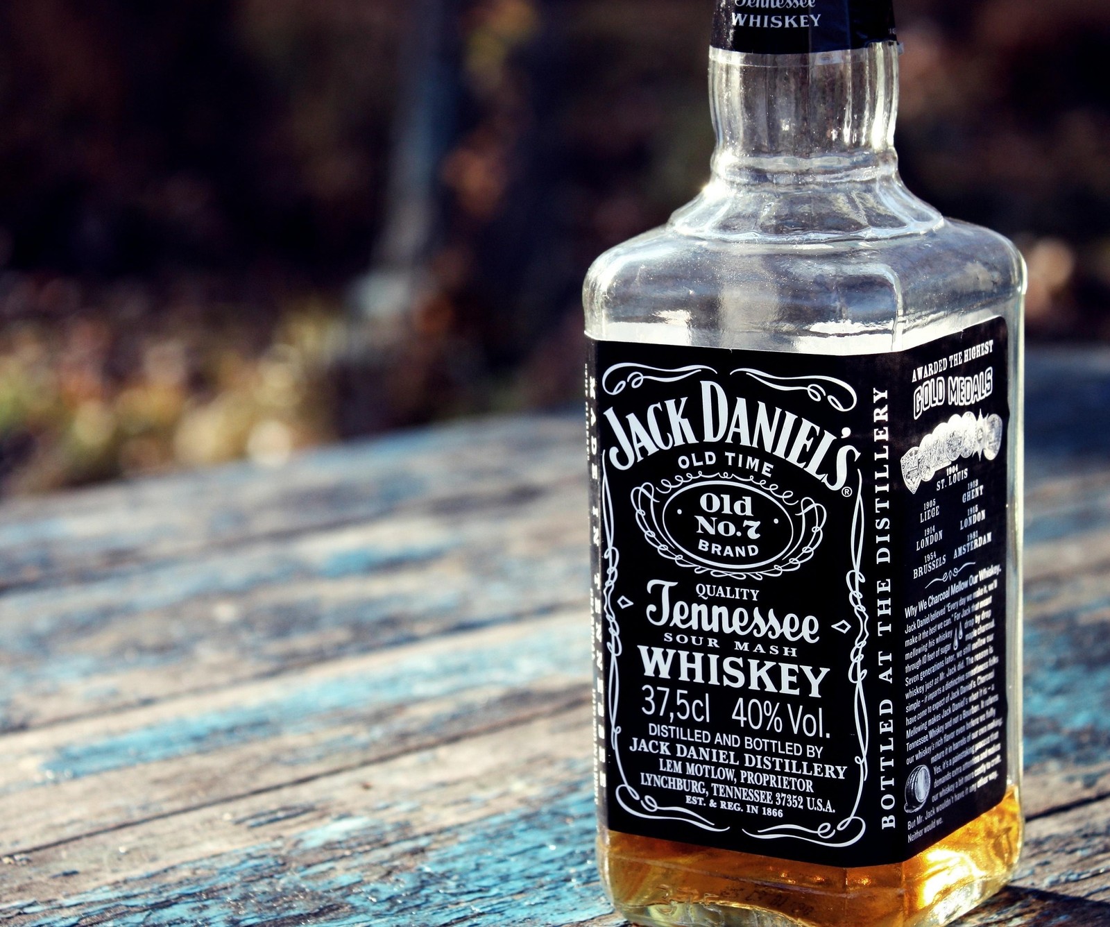 Nahaufnahme einer flasche jack daniels whiskey auf einem holztisch (alkohol, schwarz weiß, getränk, droge, whiskey)