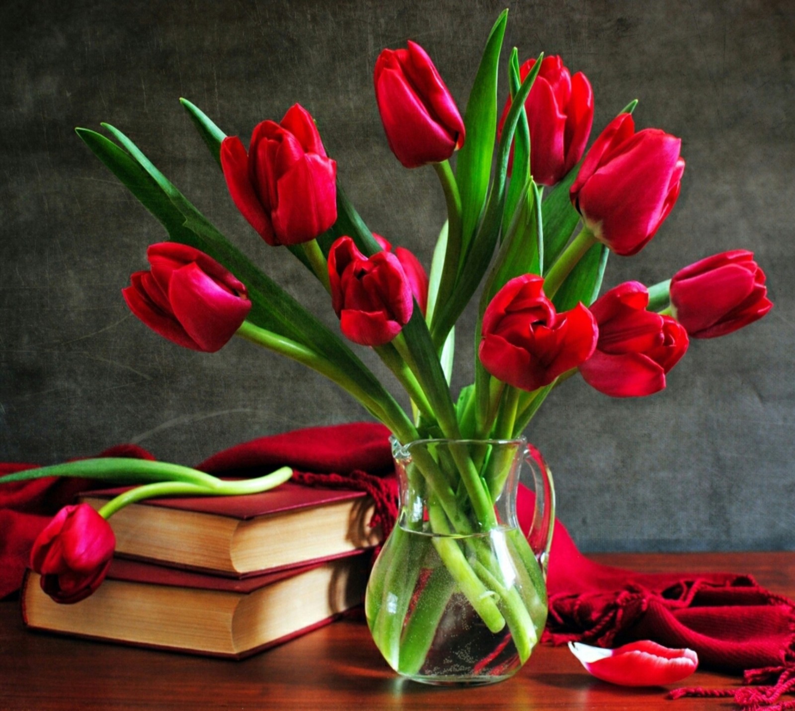 Il y a un vase avec des fleurs rouges et des livres sur une table (fleurs, nature, roses)