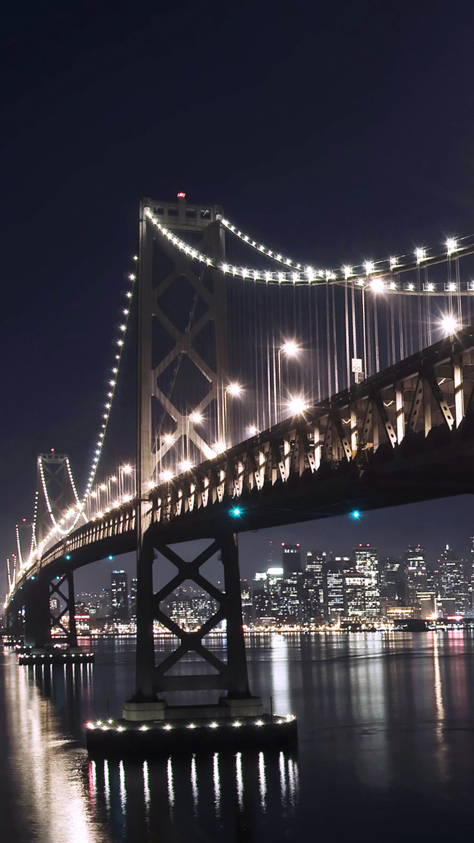 Vue d'un pont avec des lumières se reflétant dans l'eau (pont, lumières, nuit)