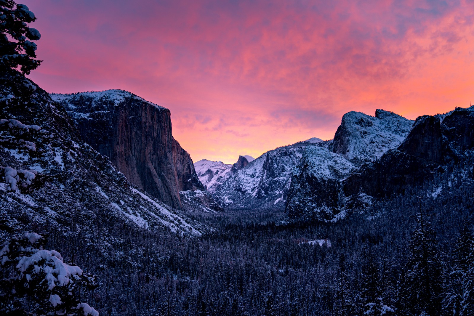 A view of a mountain range with a sunset in the background (yosemite national park, snow covered, mountains, california, purple sky)