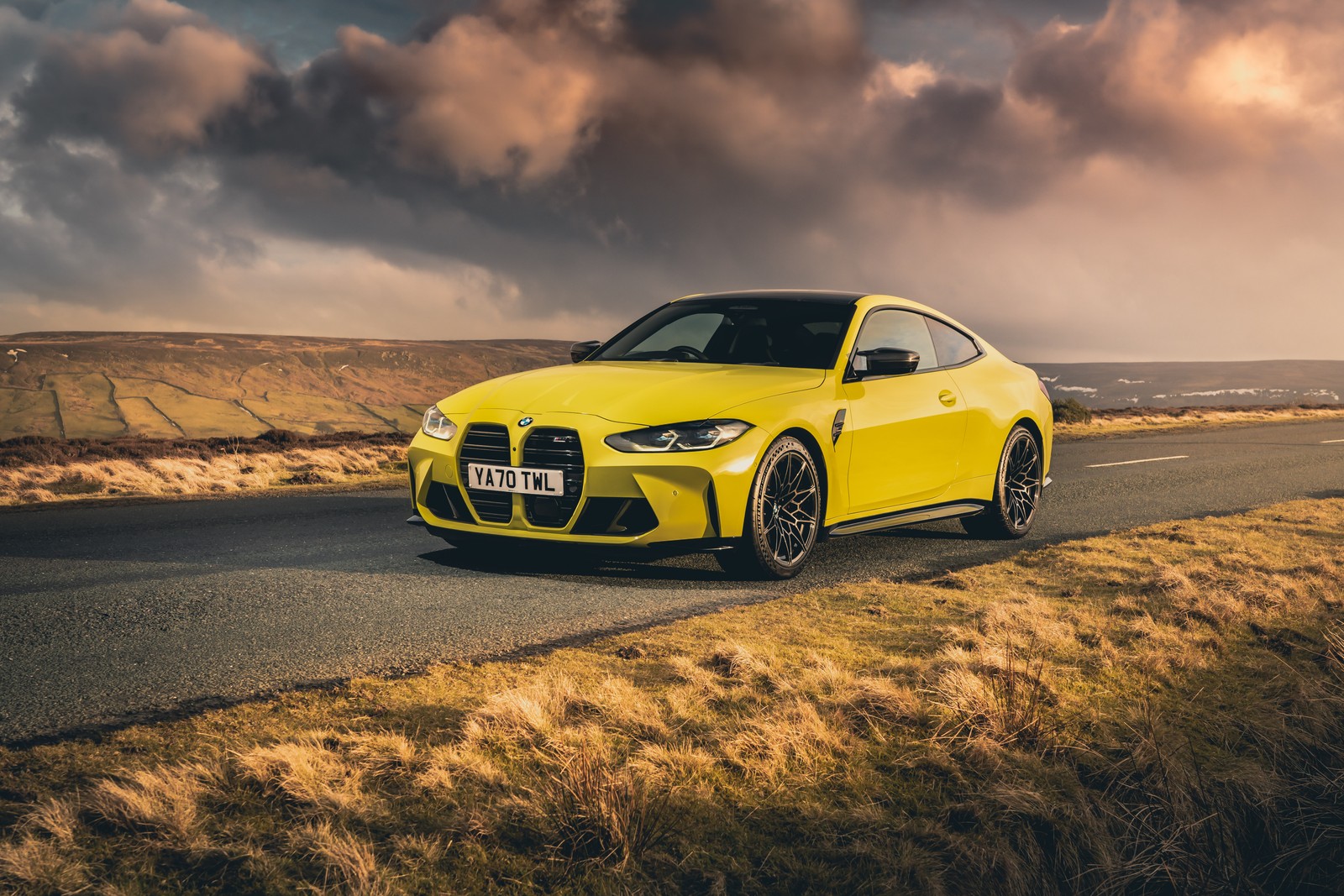 Un coche bmw amarillo conduciendo por una carretera con un cielo nublado de fondo (bmw m4 competition, 5k, 2021, asfalto, coches)