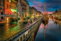 Reflejos nocturnos vibrantes a lo largo de un canal en la ciudad