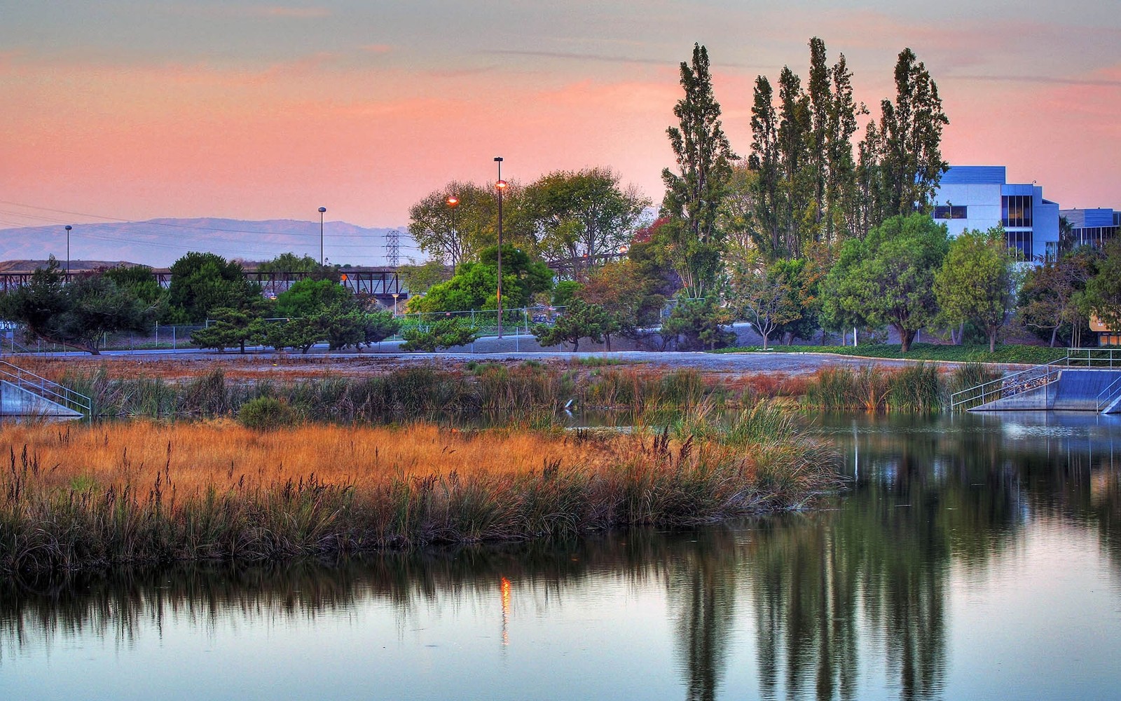 There is a boat that is sitting in the water (tree, reflection, nature, water, reservoir)