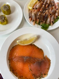 Délicieuse assiette de fruits de mer avec saumon fumé et crevettes fraîches, garnie de citron