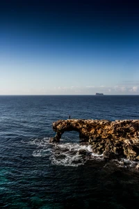 Point de vue au coucher du soleil : promontoire côtier et vagues océaniques sereines