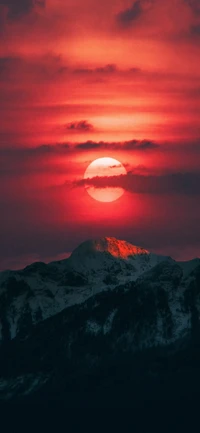 Brillante resplandor sobre picos cubiertos de nieve al anochecer