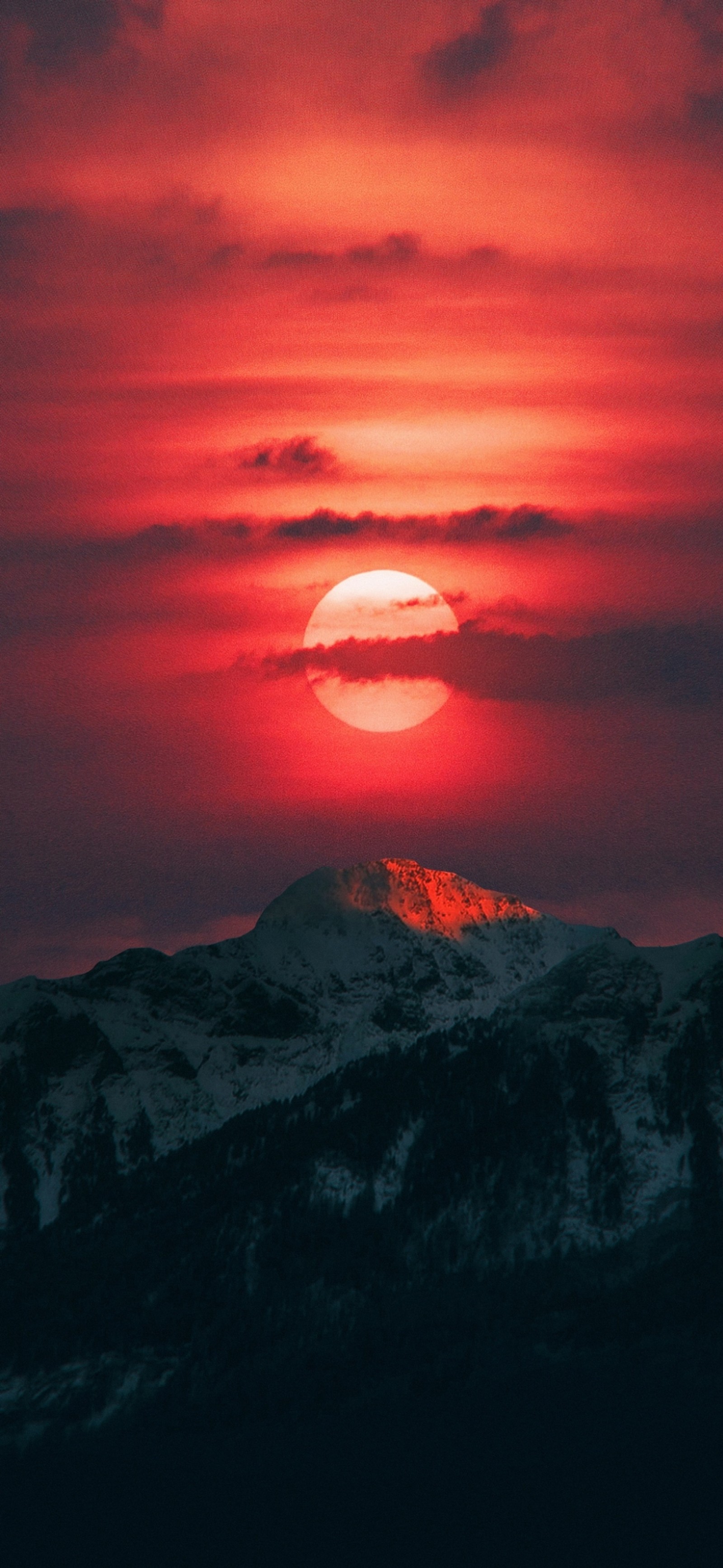 Vue d'une montagne avec un ciel rouge et un soleil (crépuscule, nuage, atmosphère, écorégion, paysage naturel)